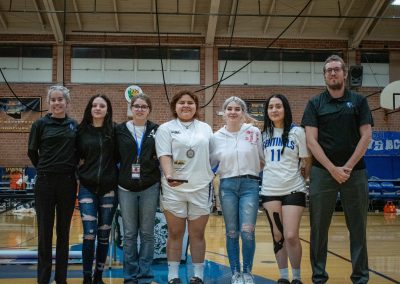 A photo of the entire Arizona Sentinel girls team in the ASDB gymnasium. They are posing with large smiles on their faces. One Sentinel player is holding up their WSBC trophy for finishing in second place.