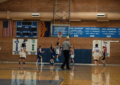 A photograph of an active WSBC basketball game in the ASDB gymnasium. On court are the competing Utah Eagle and Oregon Panther boys teams. In the photo, a Panther player is leaping towards the basket for an attempt at a layup.