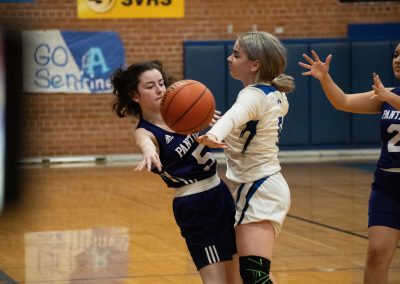A photograph of an active WSBC basketball game in the ASDB gymnasium. On court are the competing Oregon Panther and Arizona Sentinel girls teams. In the photo, a Sentinel defender forces the basketball out of bounds by stuffing an Oregon offensive pass.